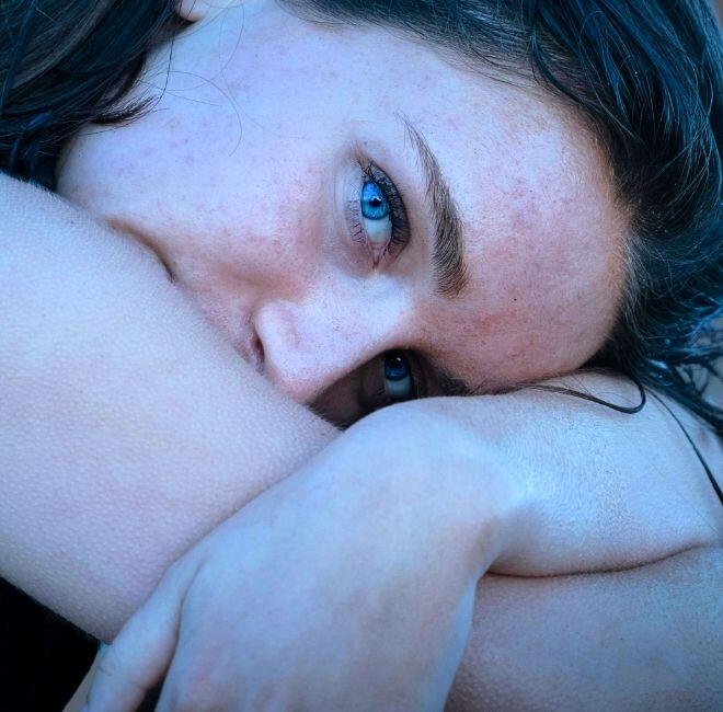 piękna kobieta z niebieskimi oczami wtulona w swoje piękna ręce jest po modelowaniu twarzy